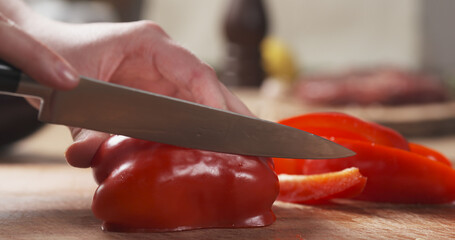 Wall Mural - female teen hands slicing red bell pepper inlong pieces for grill. wide photo