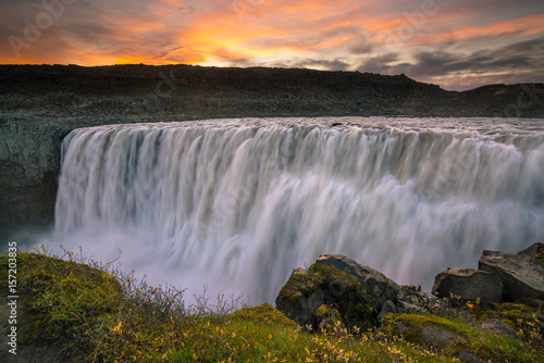 Detifoss waterfall with sunset in the background
