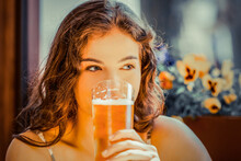 Portrait Of A Woman Drinking Beer In Bar
