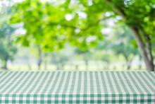 Empty Table With Green Tablecloth Over Blur Garden And Bokeh Background, For Food And Product Display Montage, Spring And Summer Season