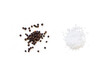 Dried whole seed of black pepper and white coarse sea salt isolated on a white background seen from above
