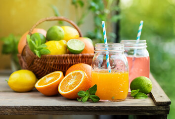 Wall Mural - Mix of fresh citrus fruits in basket and juice in glass jars.