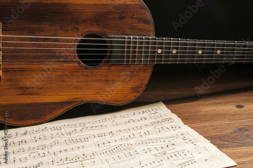Plakat Starożytna gitara akustyczna i odręczne notatki na stole