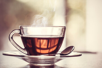 Poster - Close up the warm black tea cup on the wooden table in living room , relax with tea time concept