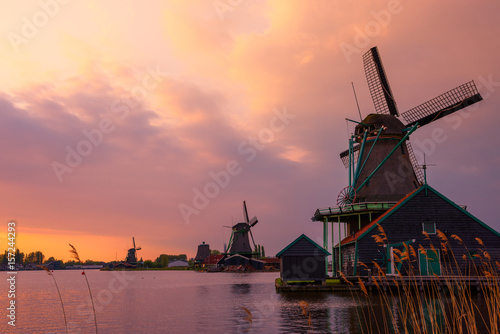 Fotografie, Obraz Traditional Dutch windmills on the canal bank at warm sunset in Netherlands near
