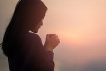 Christian Woman Praying Worship At Sunset. Hands Folded In Prayer. Worship God With Christian Concept Religion.