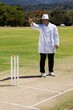 Full length of cricket umpire signaling out during match