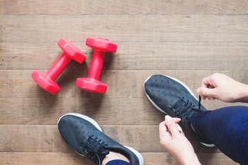 Wall Mural - Tying sport shoes, Asian woman getting ready for weight trainning. Exercise, Fitness training. Healthy lifestyle concept