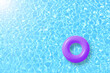 purple swimming pool ring float in blue water and sun bright. concept color summer.