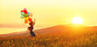Happy cheerful girl with balloons running across meadow at sunset in summer