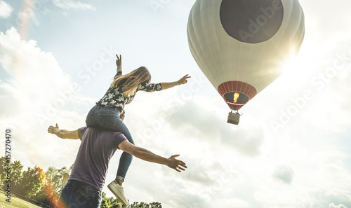 Fotomural Happy couple in love on honeymoon vacation cheering at hot air balloon - Summer
