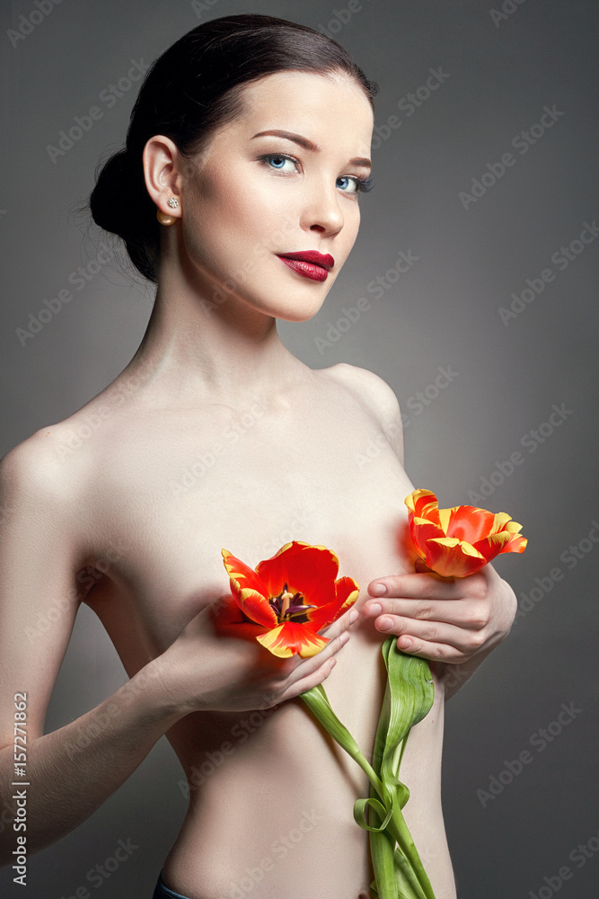 Nude Naked girl with tulips flowers in hand and perfect skin, sexy