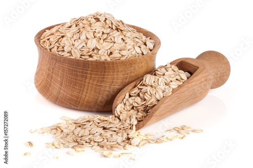 Fotografía Oat flakes in a wooden bowl with a scoop isolated on white background