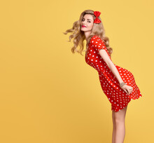 Fashion Beauty. PinUp Sensual Blond Girl Smiling In Red Polka Dots Summer Dress. Woman In Fashion Pose. Trendy Stylish Curly Hairstyle, Fashion Makeup, Red Bow. Glamour Playful Sexy Pinup Model Lady