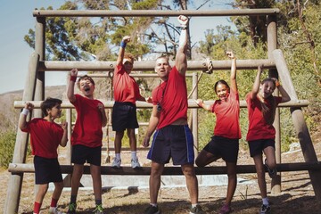 Wall Mural - trainer and kids standing together in the boot camp