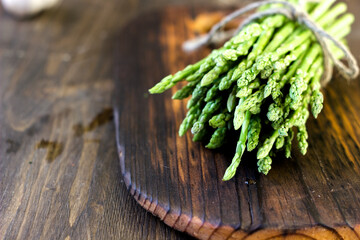 Bunch of asparagus on wooden board.