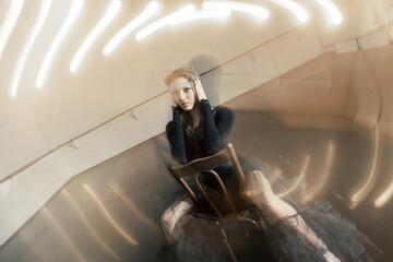 Contemporary ballet dancer on a wooden chair on a repetition