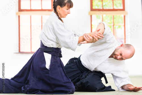 Plakat Mężczyzna i kobieta walki na treningu Aikido w szkołach sztuk walki