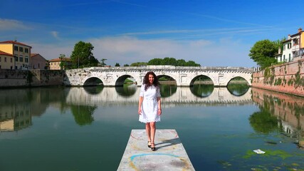 Canvas Print - smiling woman on pier with cityscape of Rimini in background