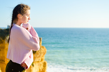 Person on mountain edge cliff enjoying sun natural outdoors background. Contemplation, inner observation lifestyle