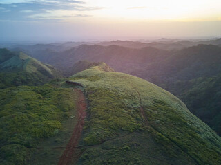 Canvas Print - Sunset over green hills landscape