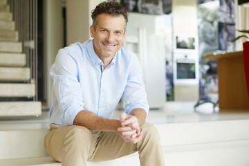 Wall Mural - Enjoy my life. Shot of a handsome smiling man relaxing his modern home. 