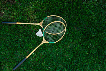 Badminton rackets and shuttlecocks isolated on green, top view, Fresh lawn
