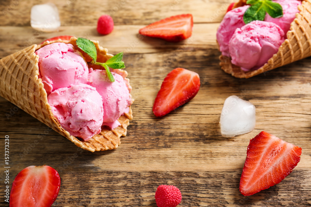 Strawberry ice-cream cones on wooden background