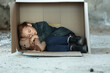 Poor little girl sleeping in cardboard box on street