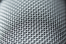 Steel Grille Background. Close-up Shot Of Microphone.
