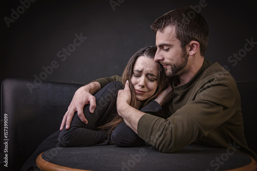 Young Man Comforting His Girlfriend Hugging Her And Keeping Her