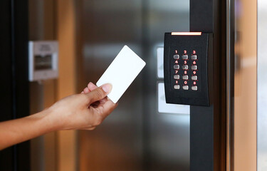 Door access control - young woman holding a key card to lock and unlock door.