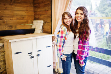 Two cheerful girls at checkered shirts on hen party.