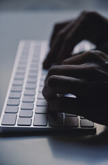 young man typing in a computer keyboard