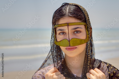 Fotografia, Obraz Girl in mask bandari woman, beach of Persian Gulf, Iran.