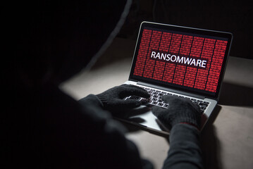 Wall Mural - Male hacker hacking into computer operating system. Internet security malware virus Trojan ransomware system breached concept