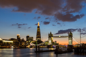 Tower Bridge, the Shard, city hall and business district in the background at night, London, Uk.