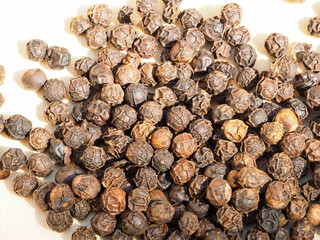 Wall Mural - Closeup image of black peppercorns on a wooden board