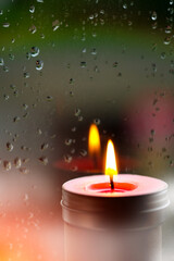 Wall Mural - Vintage image of Light of Pink Candle in the front at window with blurred rain drops and low light nature background