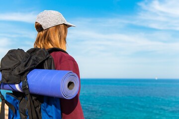 Wall Mural - Backpacker pretty girl looking at the sea