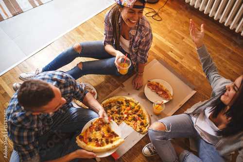 Zdjęcie XXL Grupa przyjaciele ma przyjęcia w domu i je pizzę.
