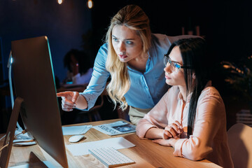 businesswomen working on computer while discussing new project together