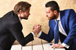 Business rivalry in office. Arm wrestling between two businessmans