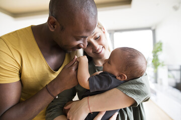 Young mother with his little daughter and her afro-american father at home.