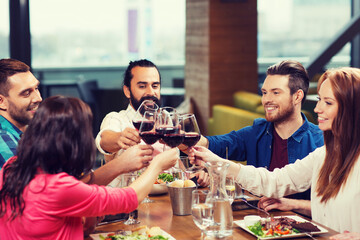 Wall Mural - friends dining and drinking wine at restaurant