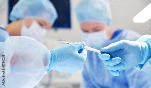 Fotomural close up of hands with scalpel at operation