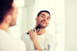© Syda Productions - man shaving beard with trimmer at bathroom
