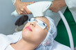 © jayzynism - Close-up of Beautician Giving Laser Epilation Treatment To Young Woman Face.