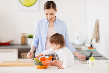 Canvas Print - happy mother and baby with food at home kitchen