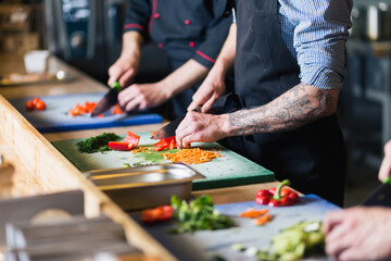 Chef cuts the vegetables into a meal. Preparing dishes. A woman uses a knife and cooks.